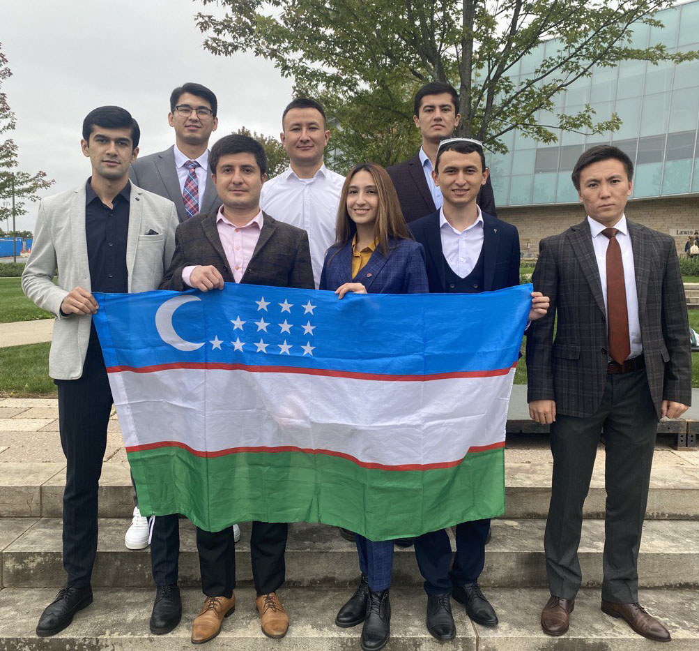 Uzbekistan students holding their flag on Katz Lawn